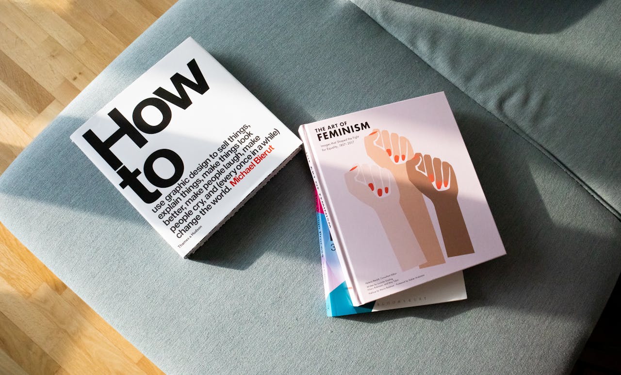 pexels-photo-15555865 A collection of books on feminism and design resting on a stylish sofa.